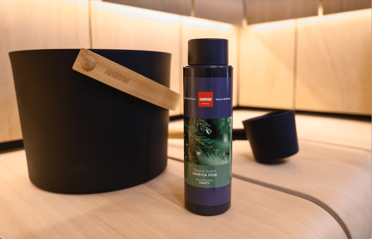 Essência de Sauna Harvia – Aroma de Pinho, garrafa ao lado de balde.