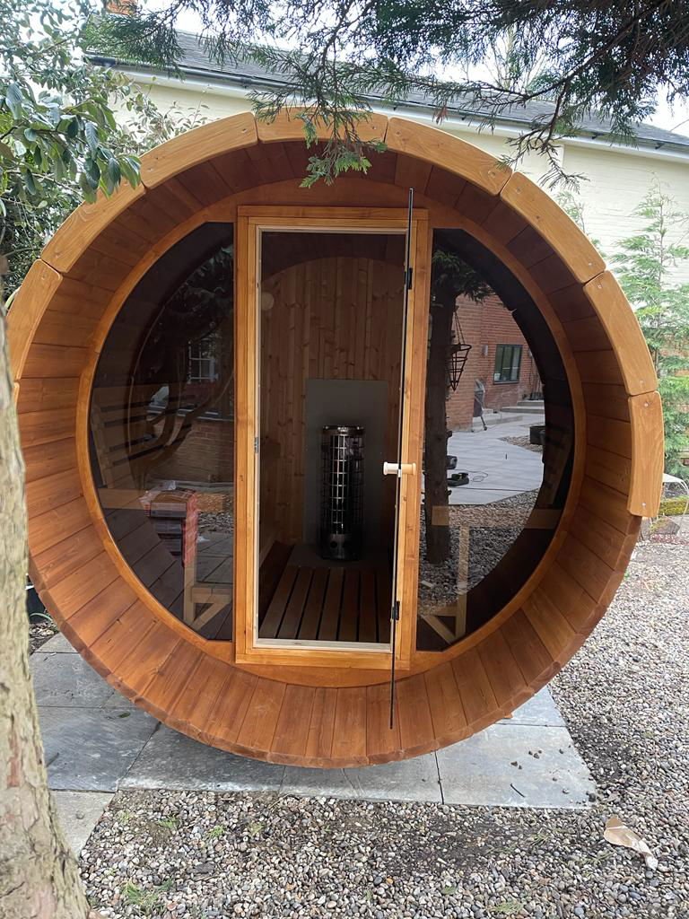 Sauna Barrel 280 Deluxe com frente de vidro e terraço.