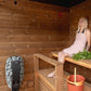 Sauna Exterior Nordic Dawn em uso, mulher relaxando.