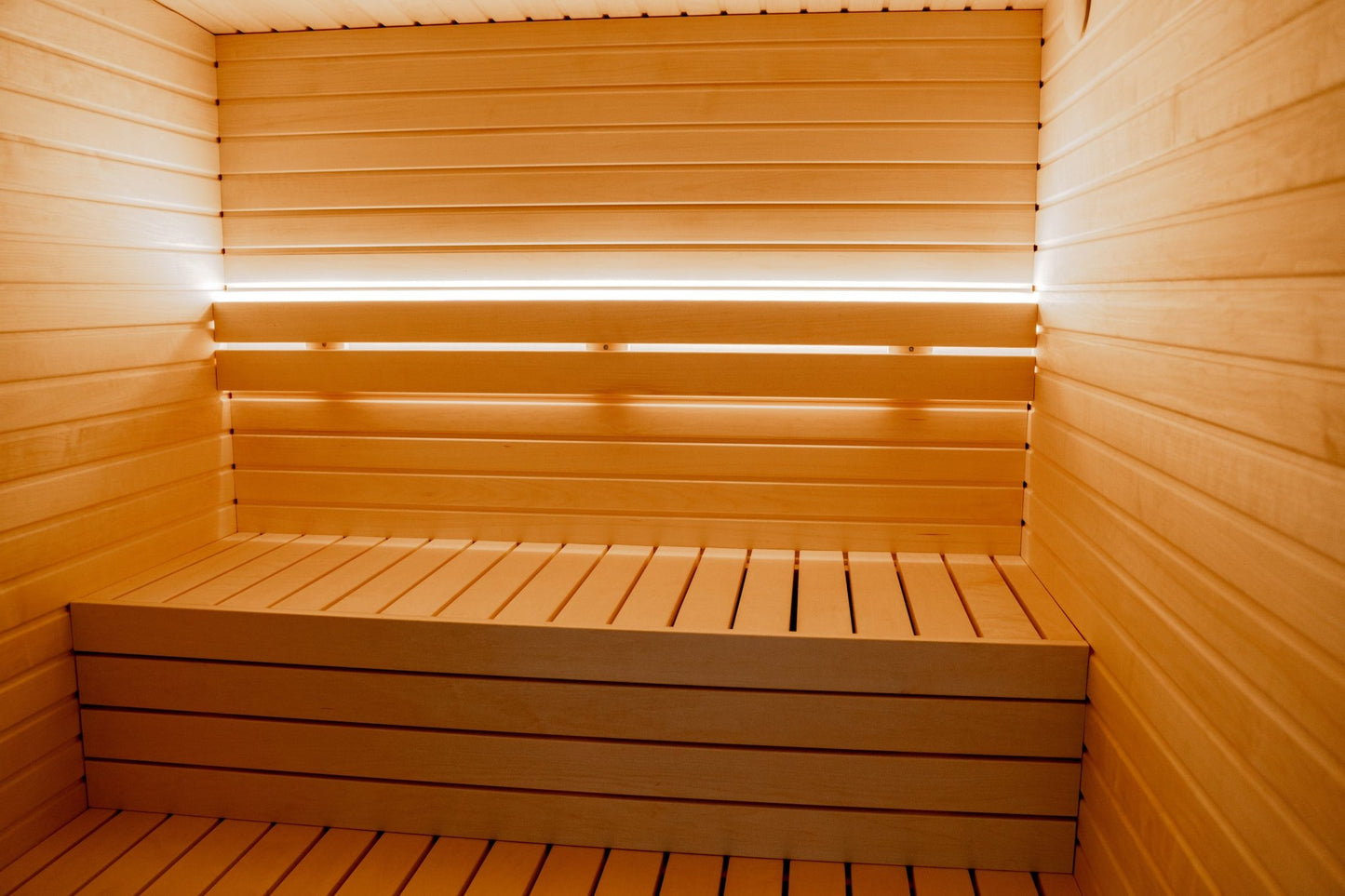 Sauna Exterior Lumi (Isolada) com banco de madeira em sauna.